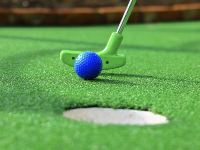 Indoor mini golf attraction with bright lighting