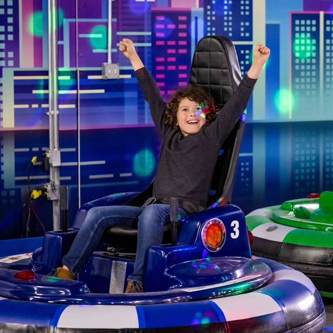 Guests riding a colorful indoor spinning coaster